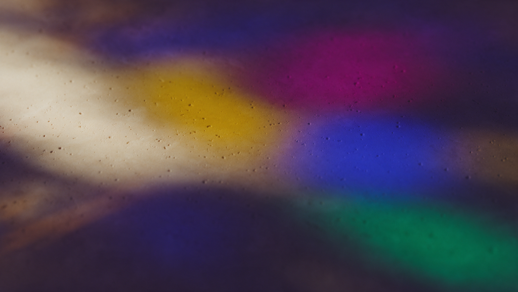 Soft, out-of-focus wash of purple, blue, gold and green light