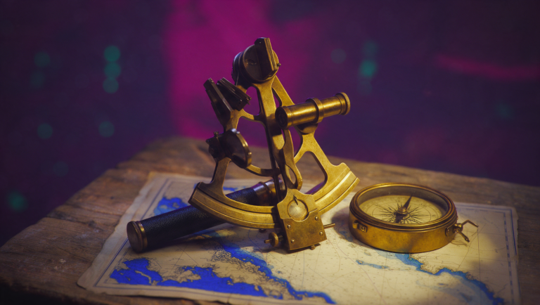 Brass sextant and compass resting on a nautical chart